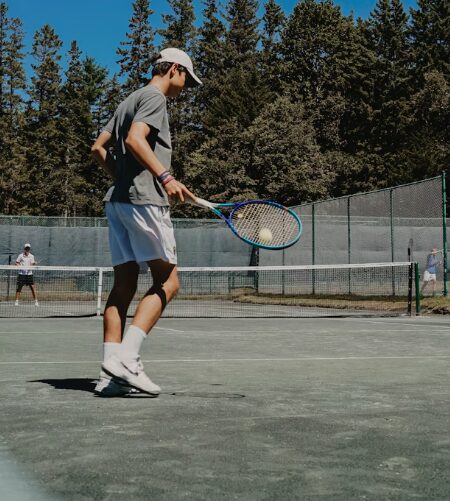Tennis player bouncing a tennis ball with their racket